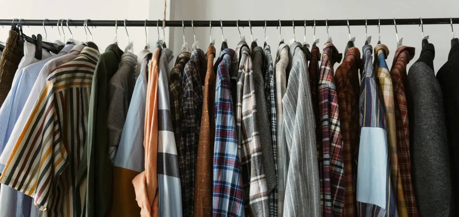 Customer-centric banking, a rail of shirts and jackets in mixed checks and stripes.