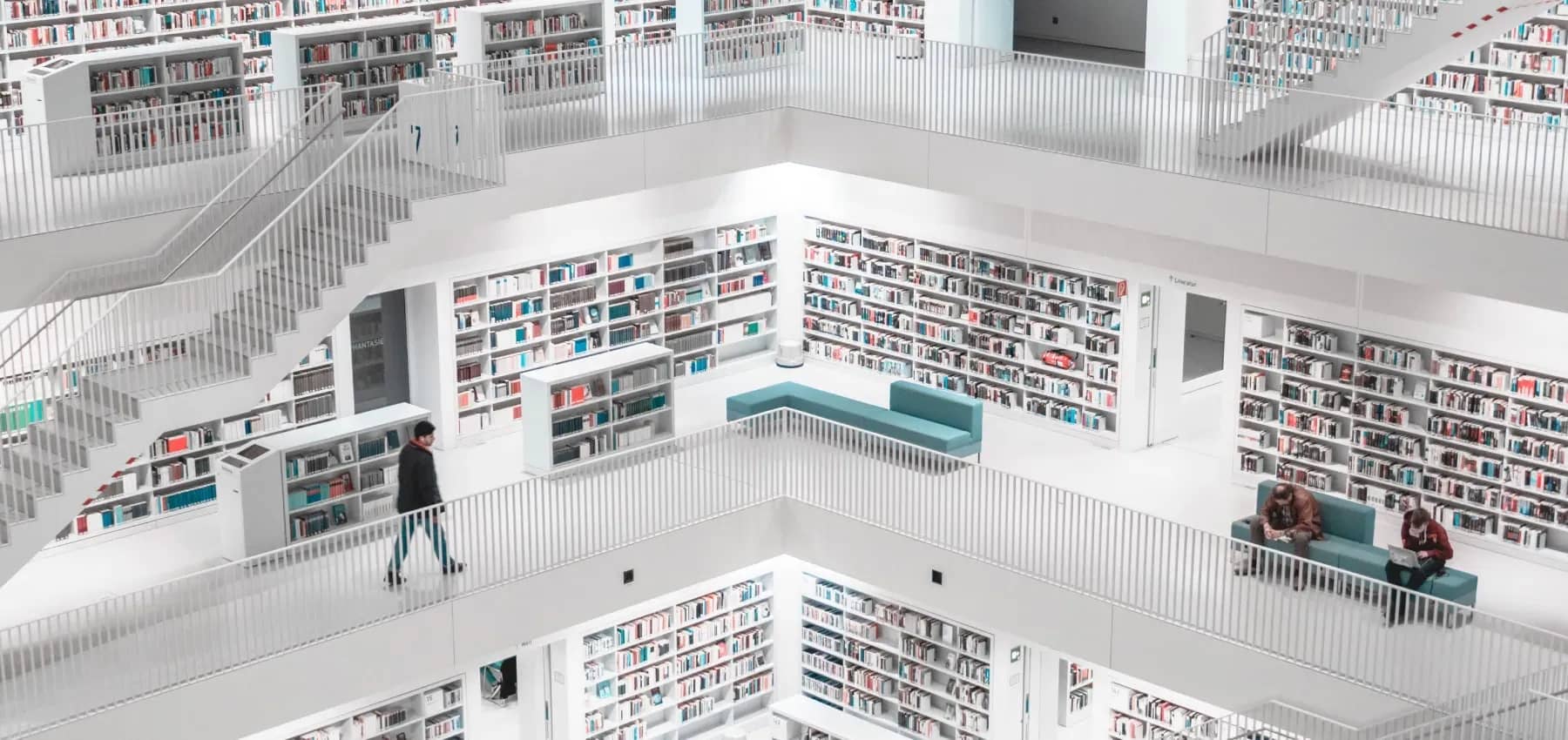 Corporate foresight, a bright modern library of tall bookshelves and stepped seating.