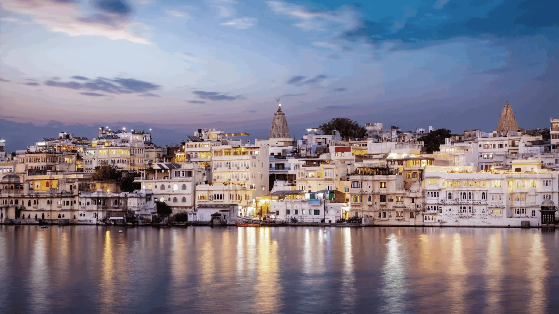 India's largest family offices, a hillside city of white buildings lit at dusk.