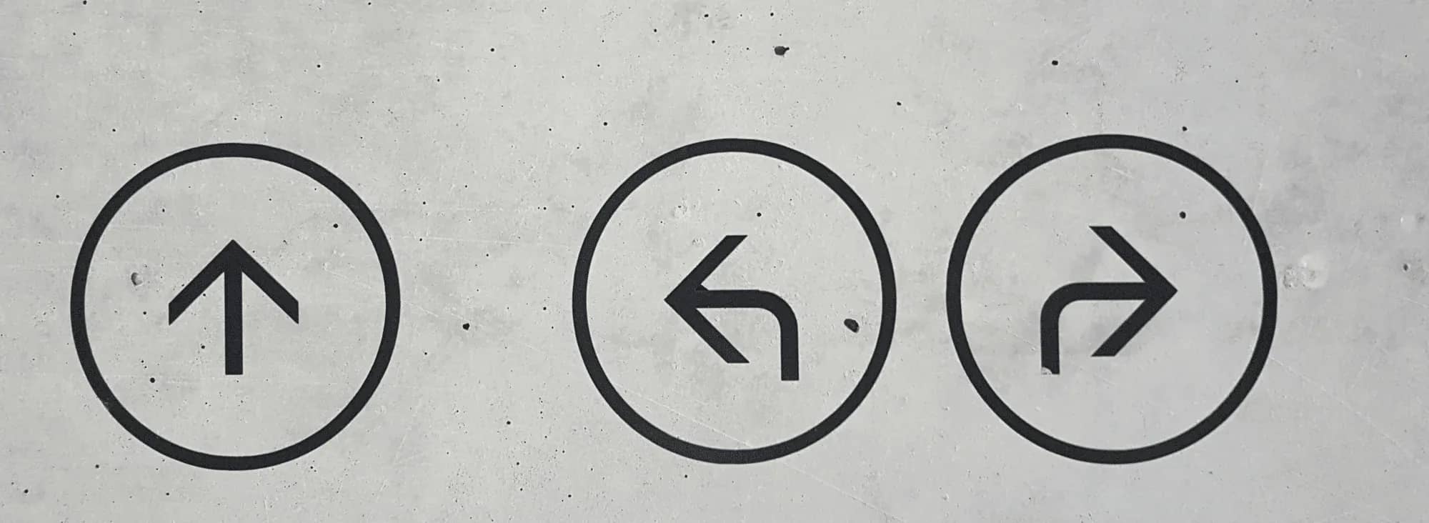 Interest rates and family office strategy, three road signs showing arrows on a concrete wall.