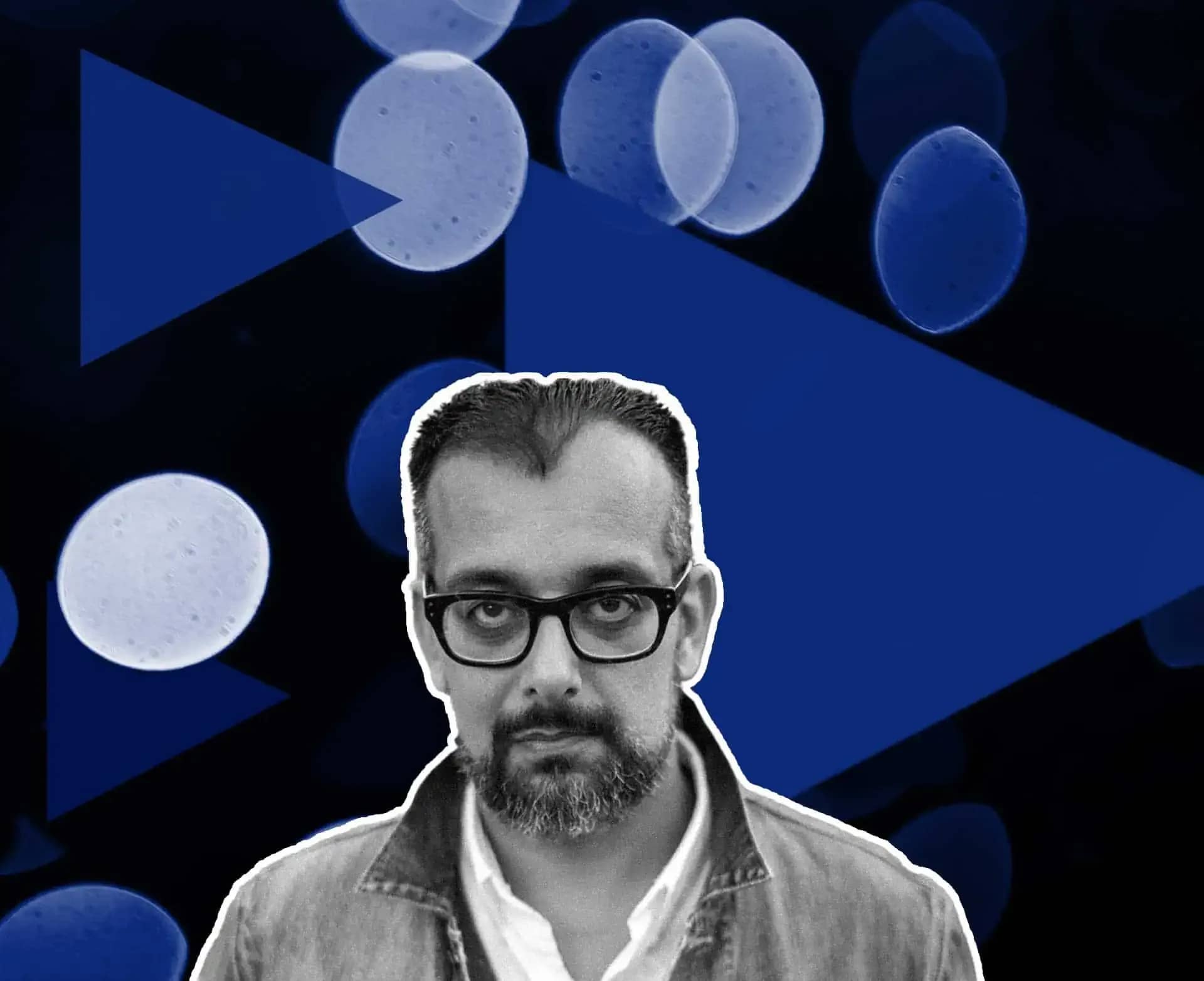 Suroosh Alvi net worth, a monochrome portrait of a man in glasses beside a pale circular motif on navy.