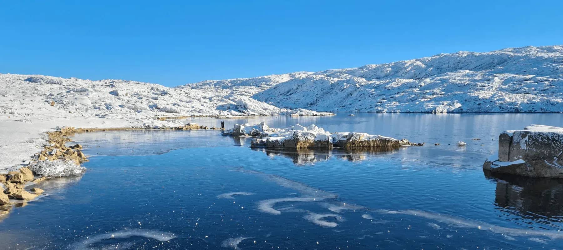 Family office AI software, a snow-covered shoreline meeting deep blue water.