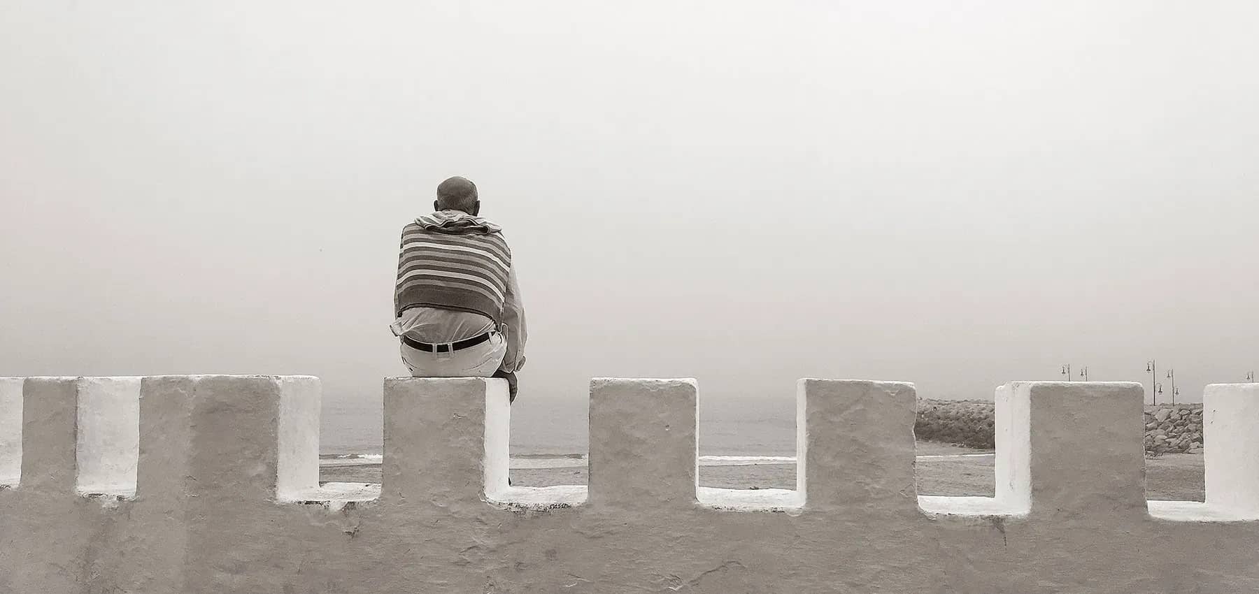 Attracting investment, a person sitting alone on a concrete block in thick mist.