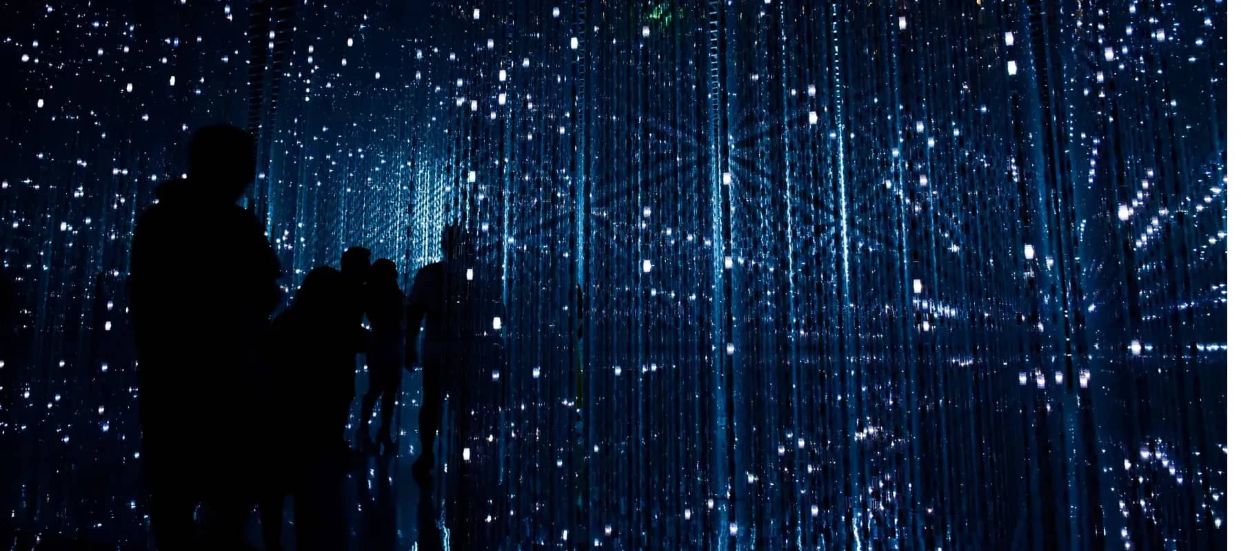 CRM for family offices, silhouetted figures before a wall of blue digital light.
