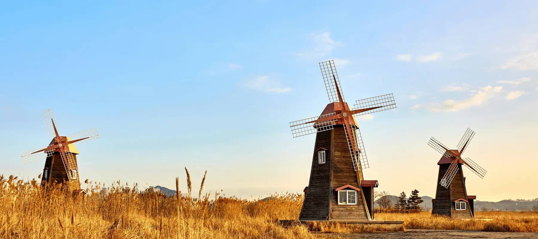 ESG strategy, wooden windmills standing against a golden sunset.