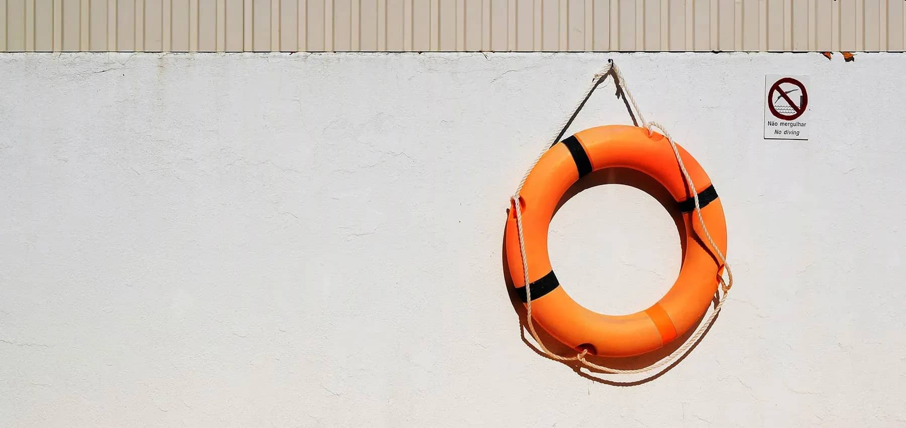 Family office trust, an orange lifebuoy mounted on a white wall.