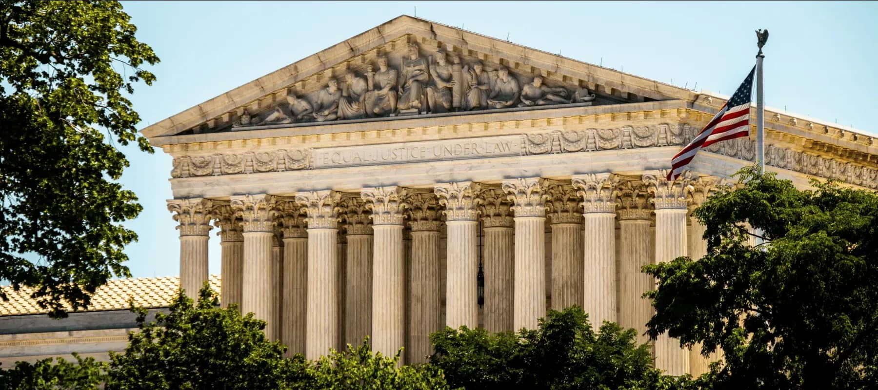 State and federal reporting, the columned facade of the US Supreme Court beside a flag.