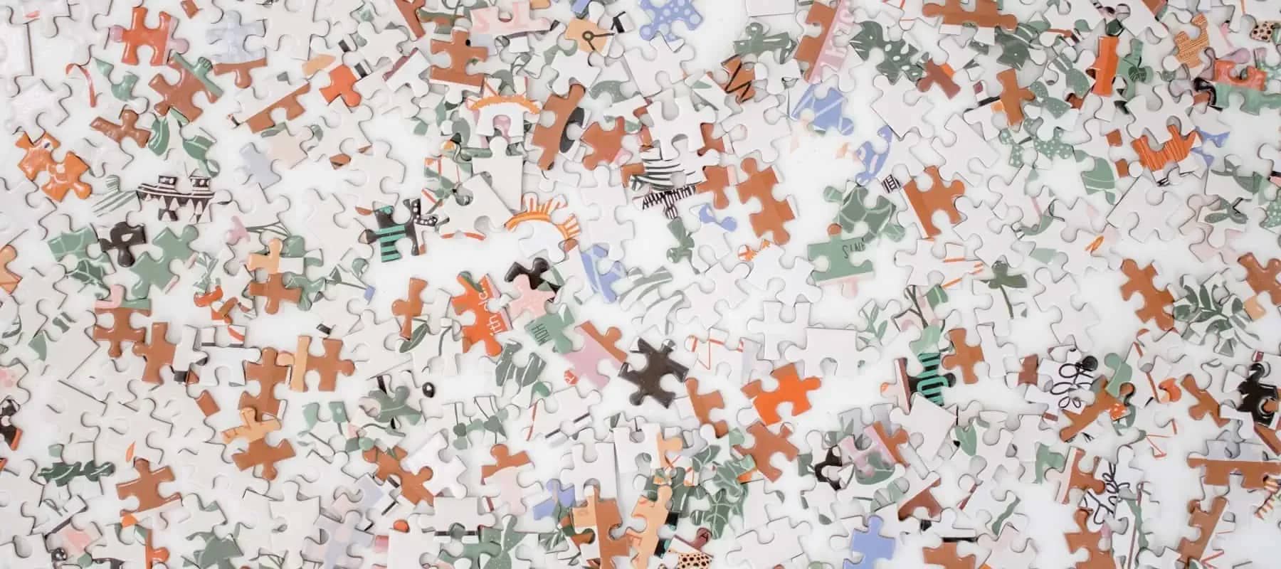 Private equity investment, scattered jigsaw pieces across a white surface.