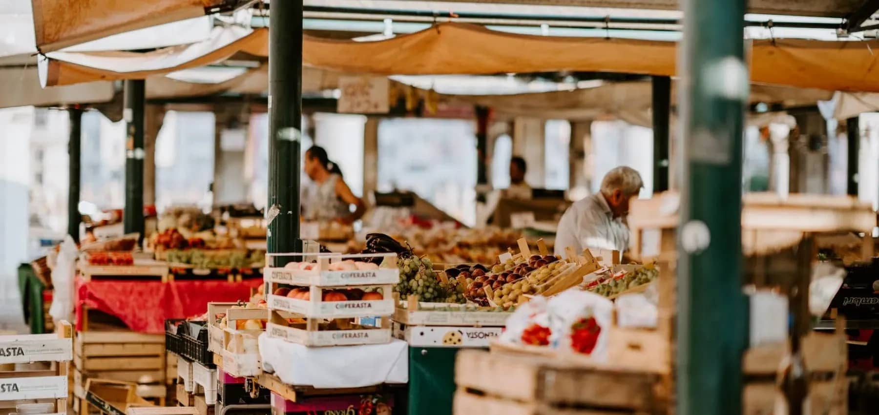Direct and venture capital investment, a covered market lined with produce stalls.