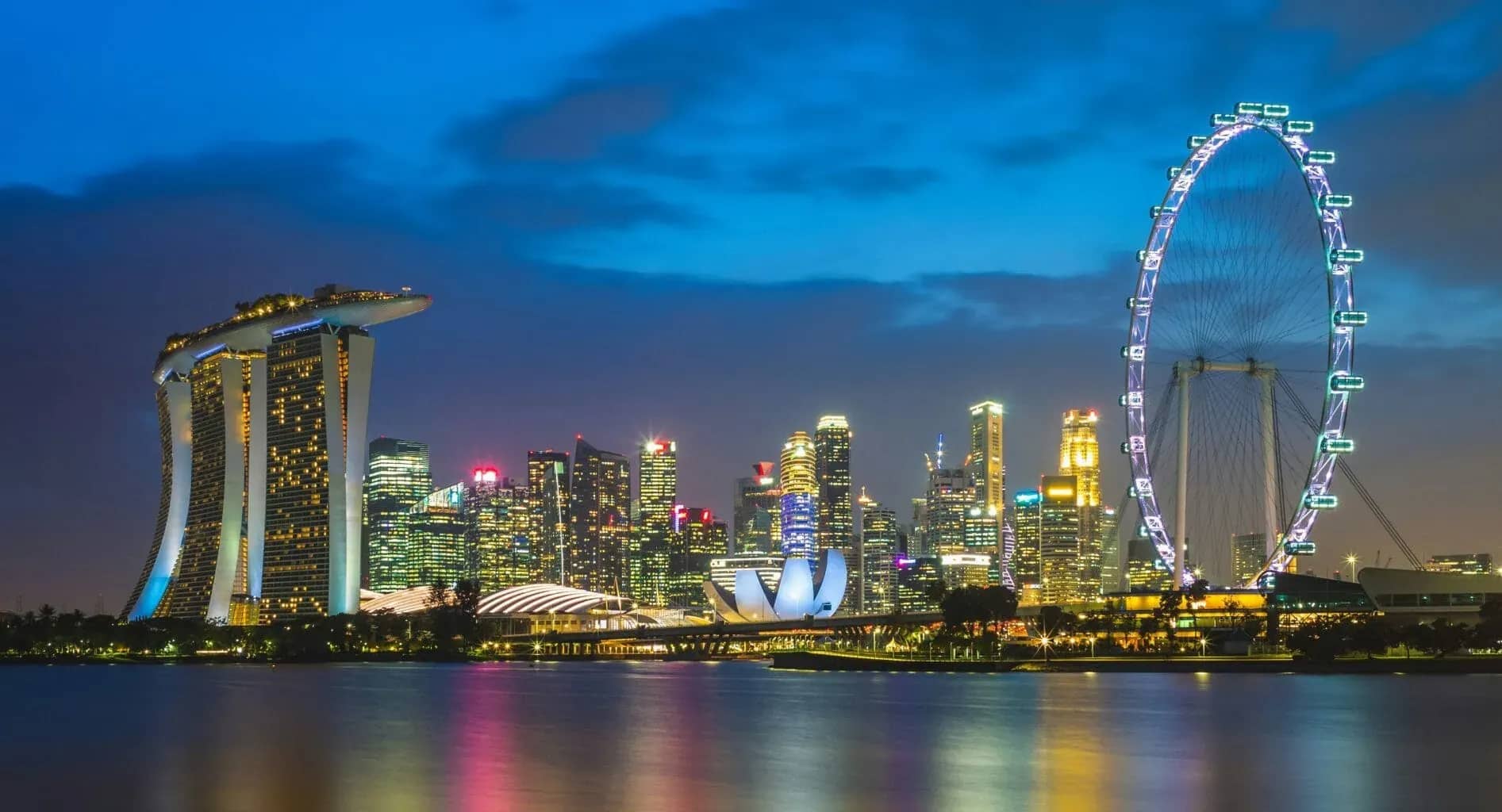 Family offices in Singapore, the Marina Bay skyline lit at dusk.