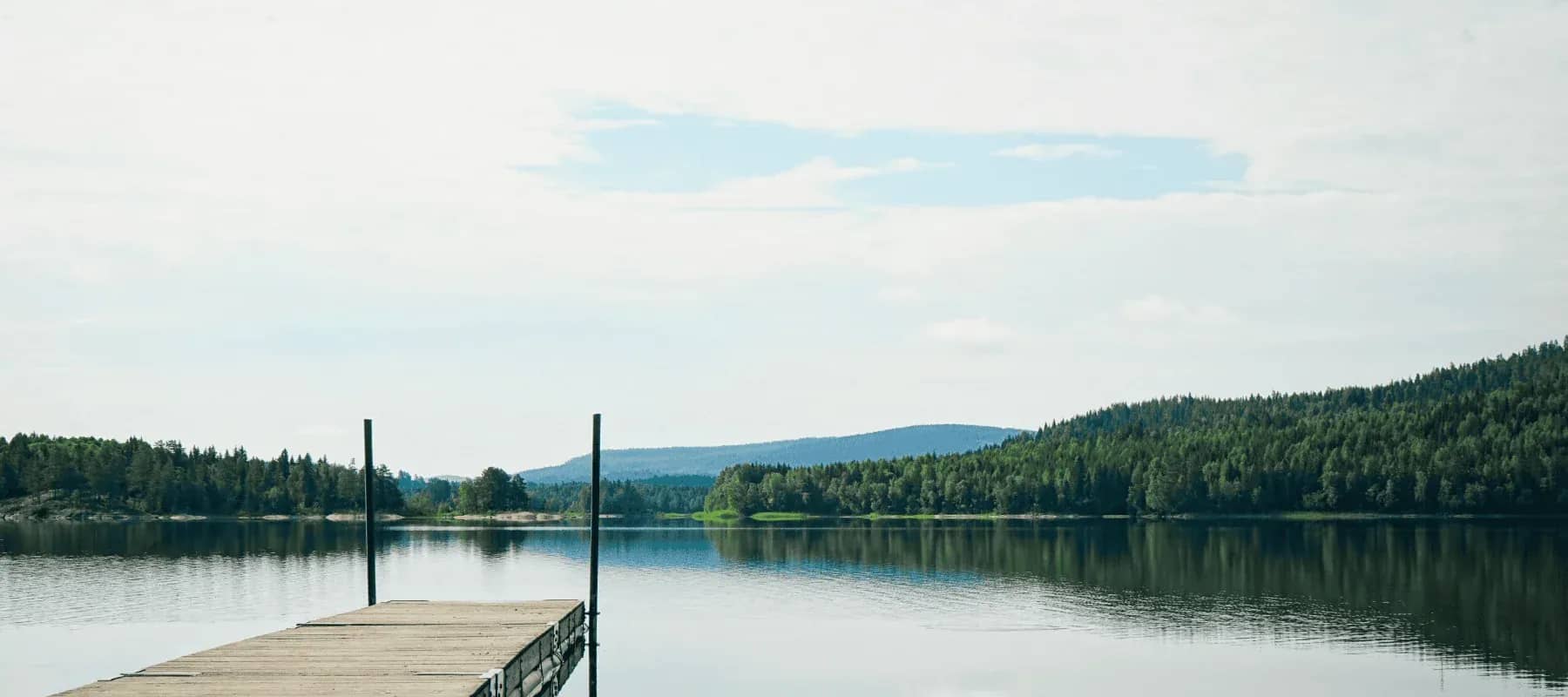 Health and longevity strategies, a still lake below forested hills.