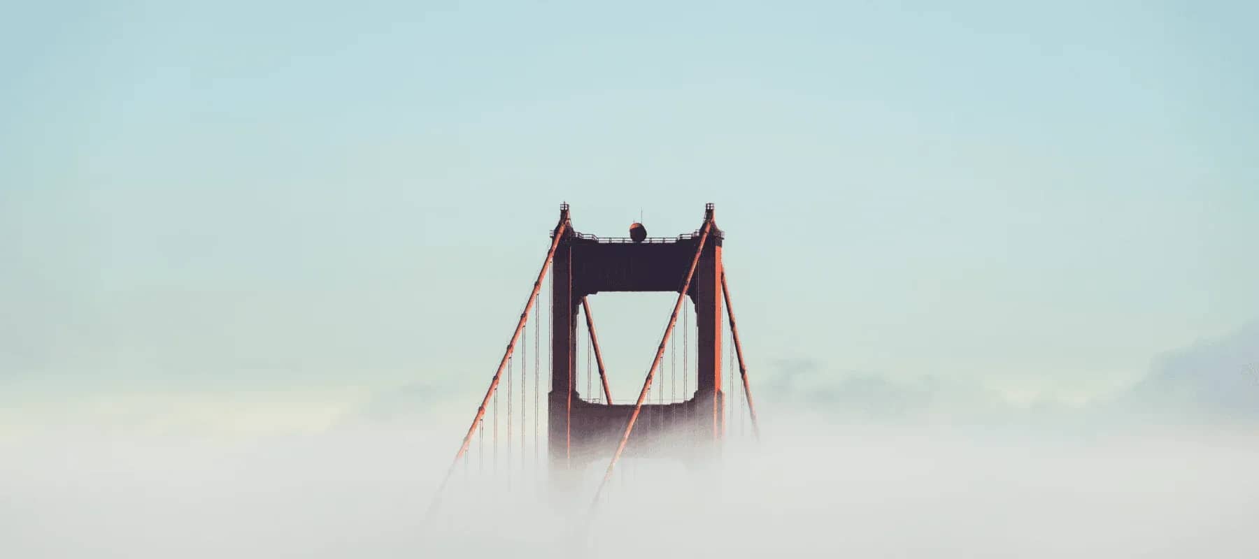 The innovation challenge, a suspension bridge tower rising against a pale sky.