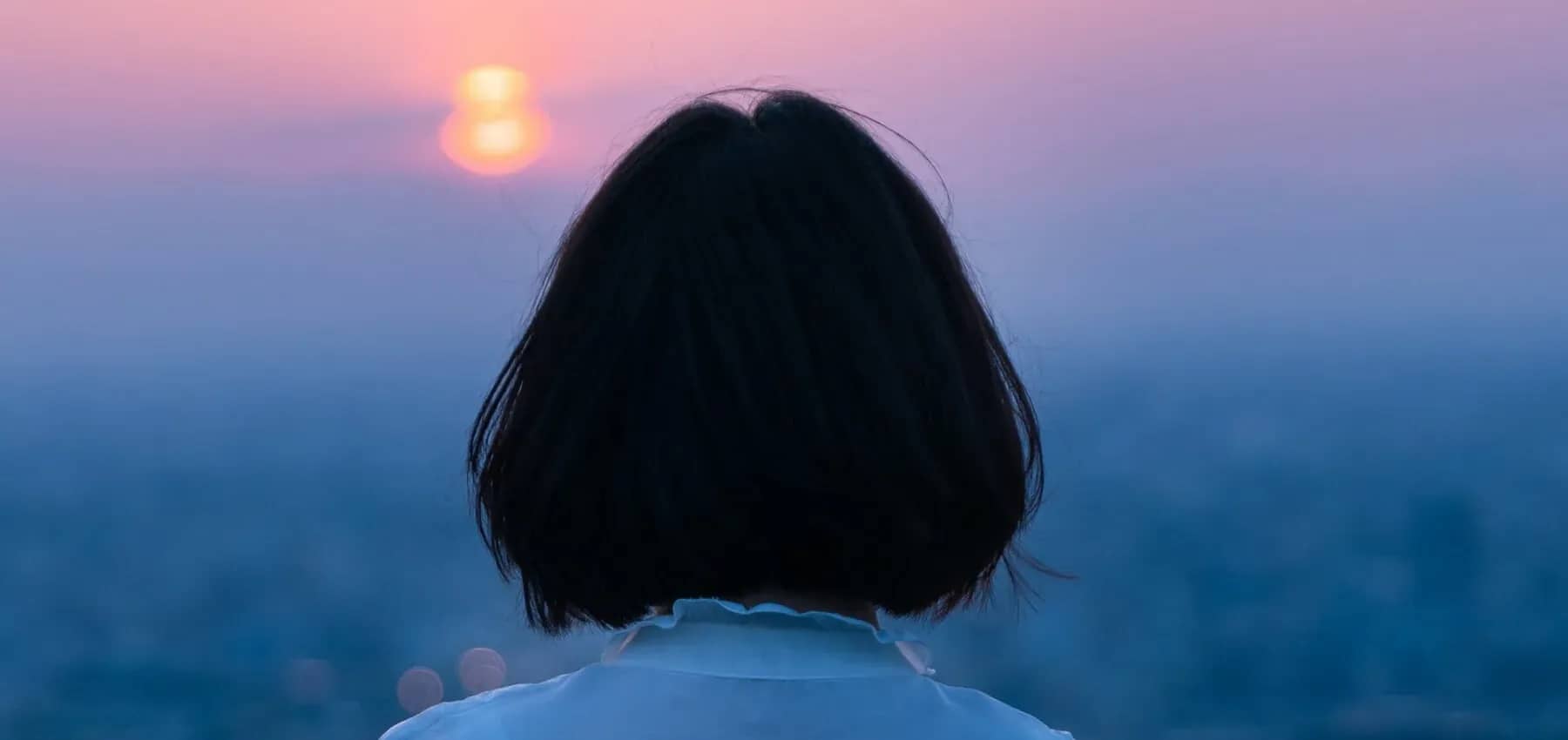 Neuroplasticity and change, the back of a person's head silhouetted against soft blue light.