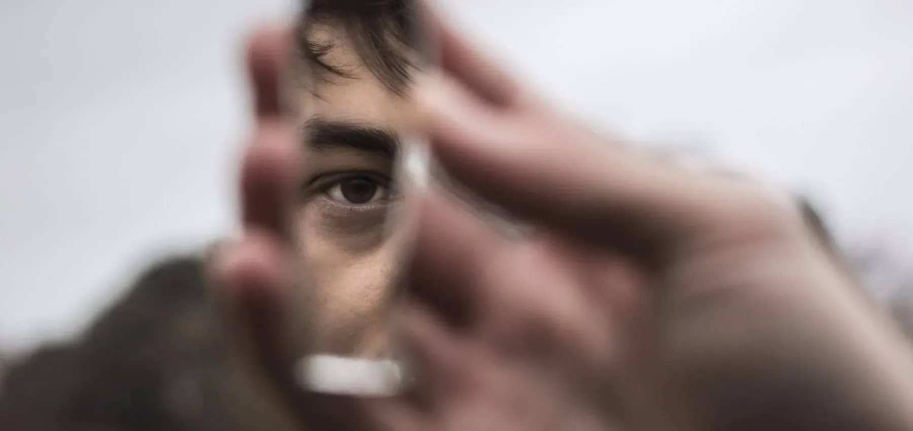 Human rights in impact investing, a close-up of an eye behind a hand-held lens.
