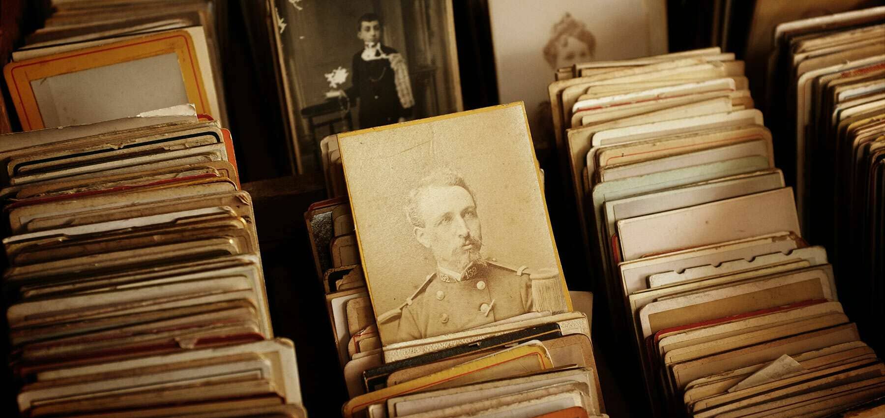 Family inheritance, a box of antique photographs with a Victorian portrait standing upright.