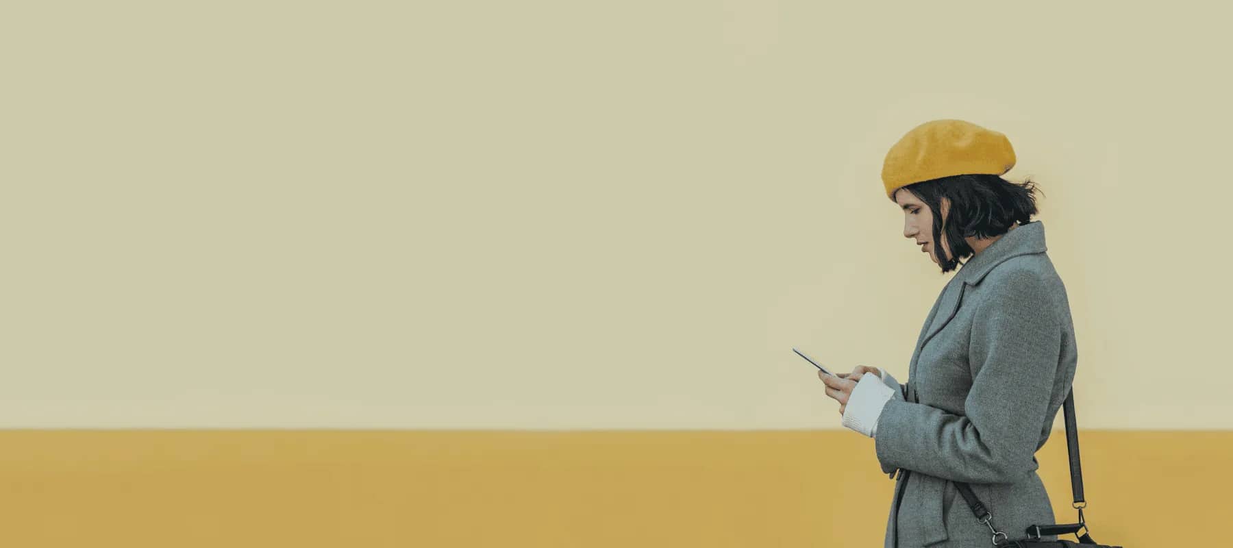 Digital concierge solutions, a woman in a yellow beret looking at her phone.