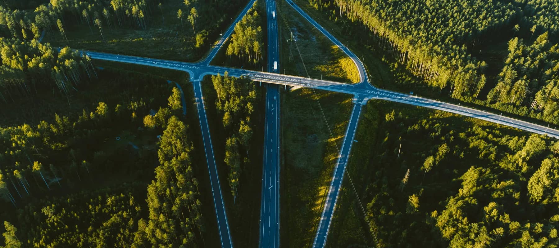Family office software partnerships, an aerial view of motorway junctions cutting through forest.