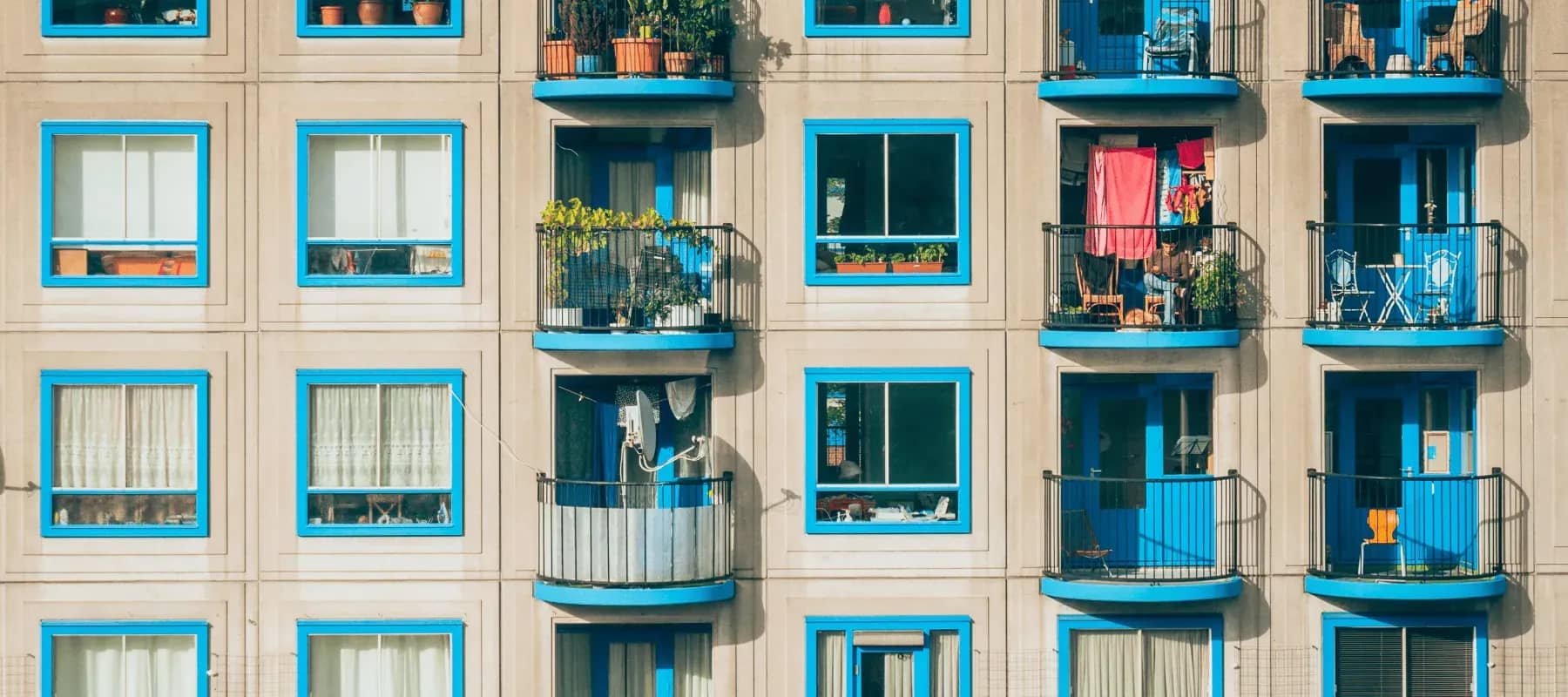 Outside real estate resources, an apartment facade of blue-framed windows and balconies.