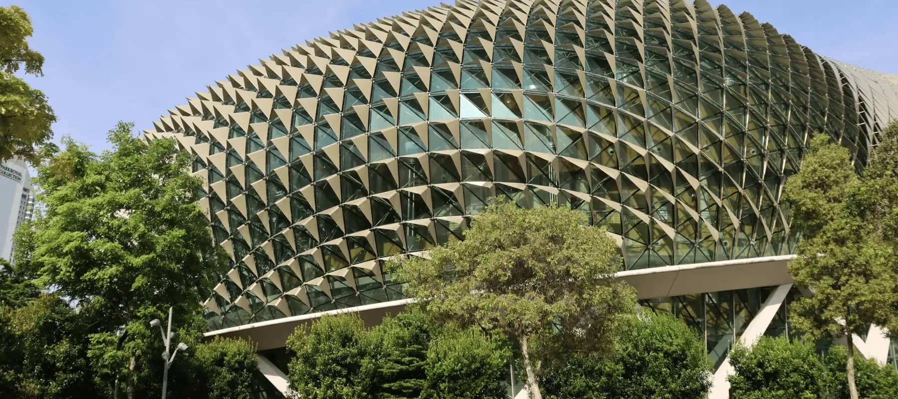 Family office wealthtech in Singapore, a faceted glass canopy curving above dense greenery.