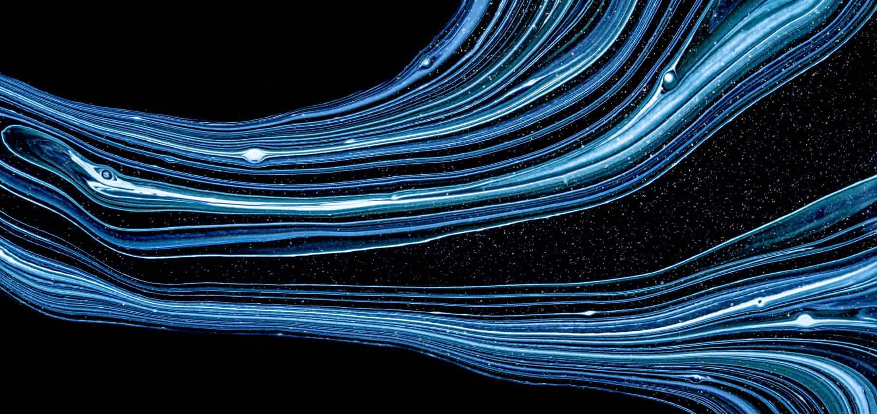 Venture deal flow, streaks of blue light flowing across a dark field.