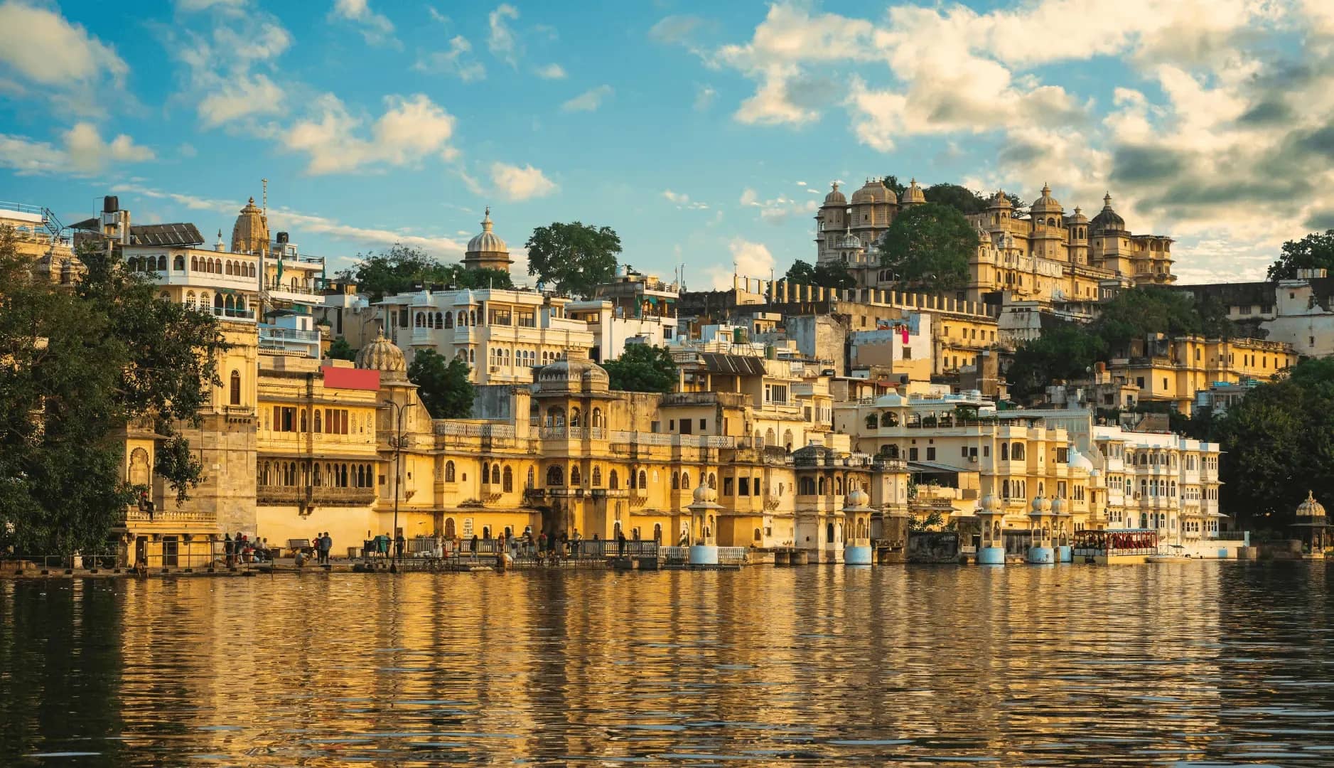 Scalable wealth management platform, tiered ochre buildings of an Indian hillside city rising above the treeline.