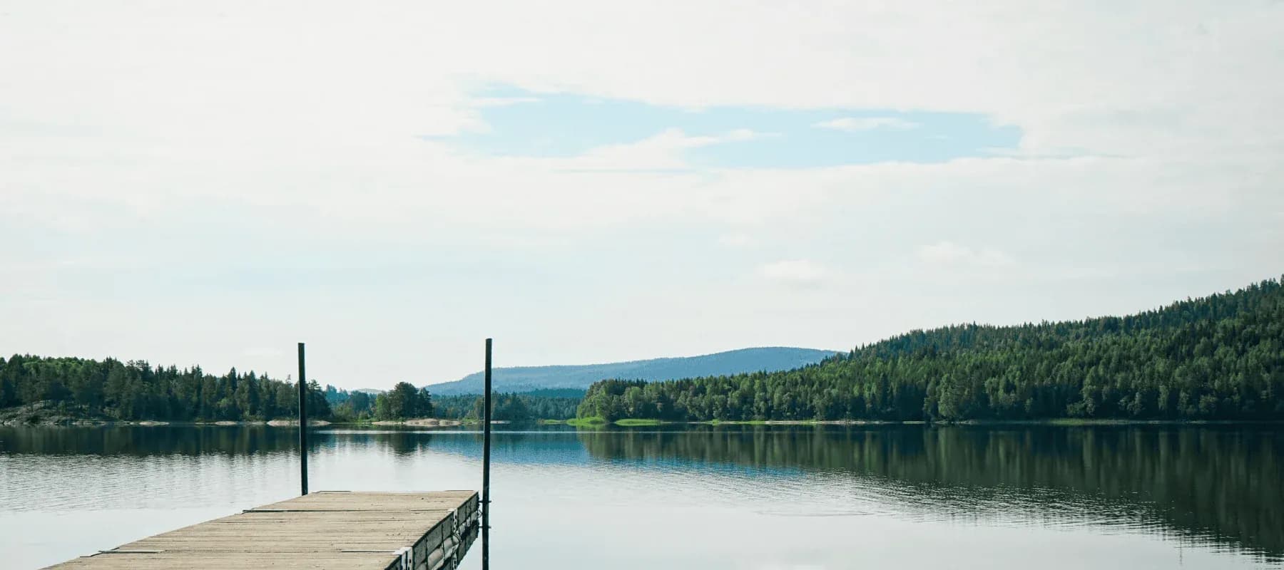 Health and longevity strategies, a still lake below forested hills.