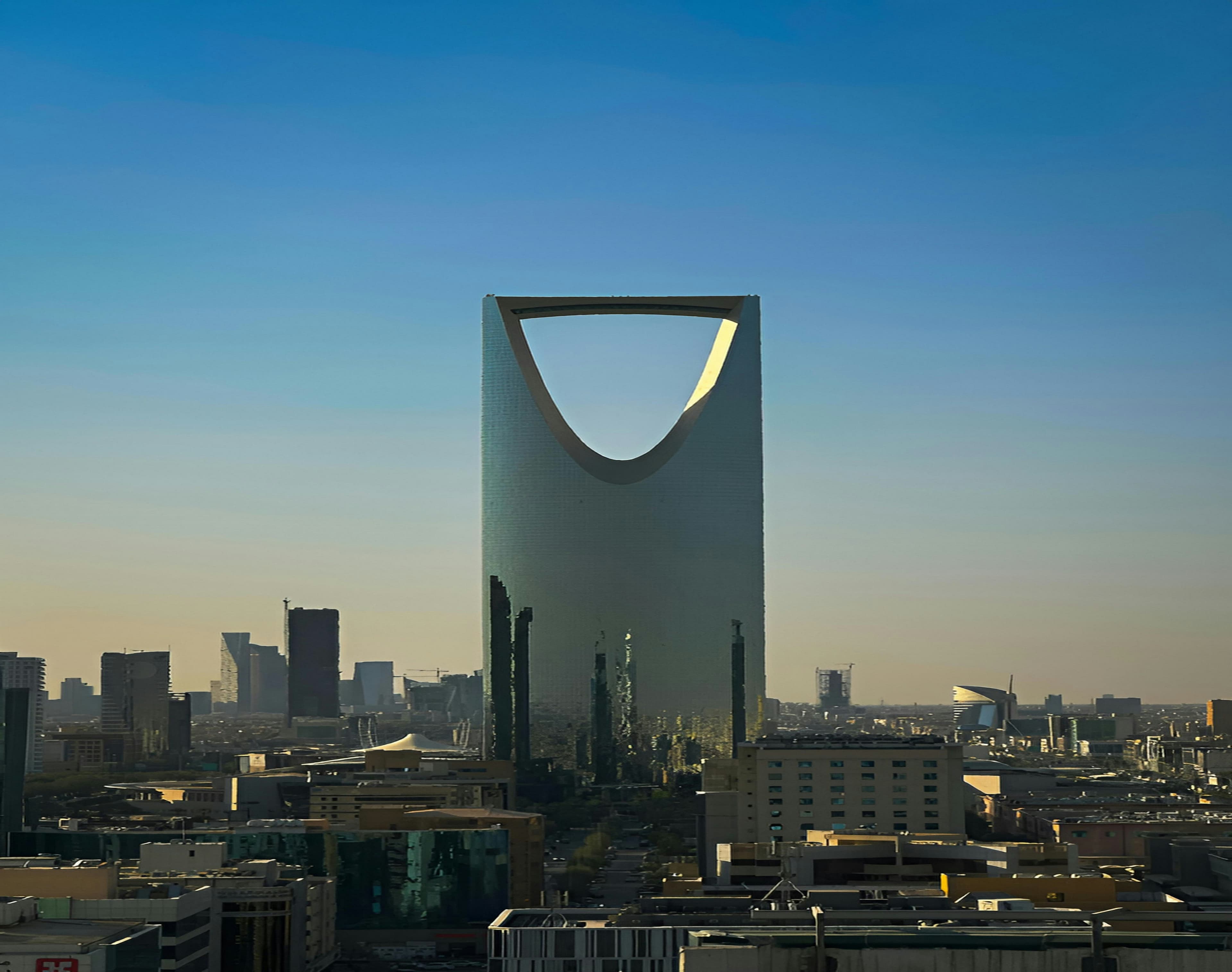 Kingdom Tower rising above palm trees in Riyadh, Saudi Arabia family office hub