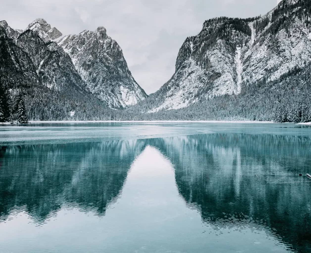 Fintech growth journey, a frozen alpine lake ringed by snow-covered pines below a mountain ridge.