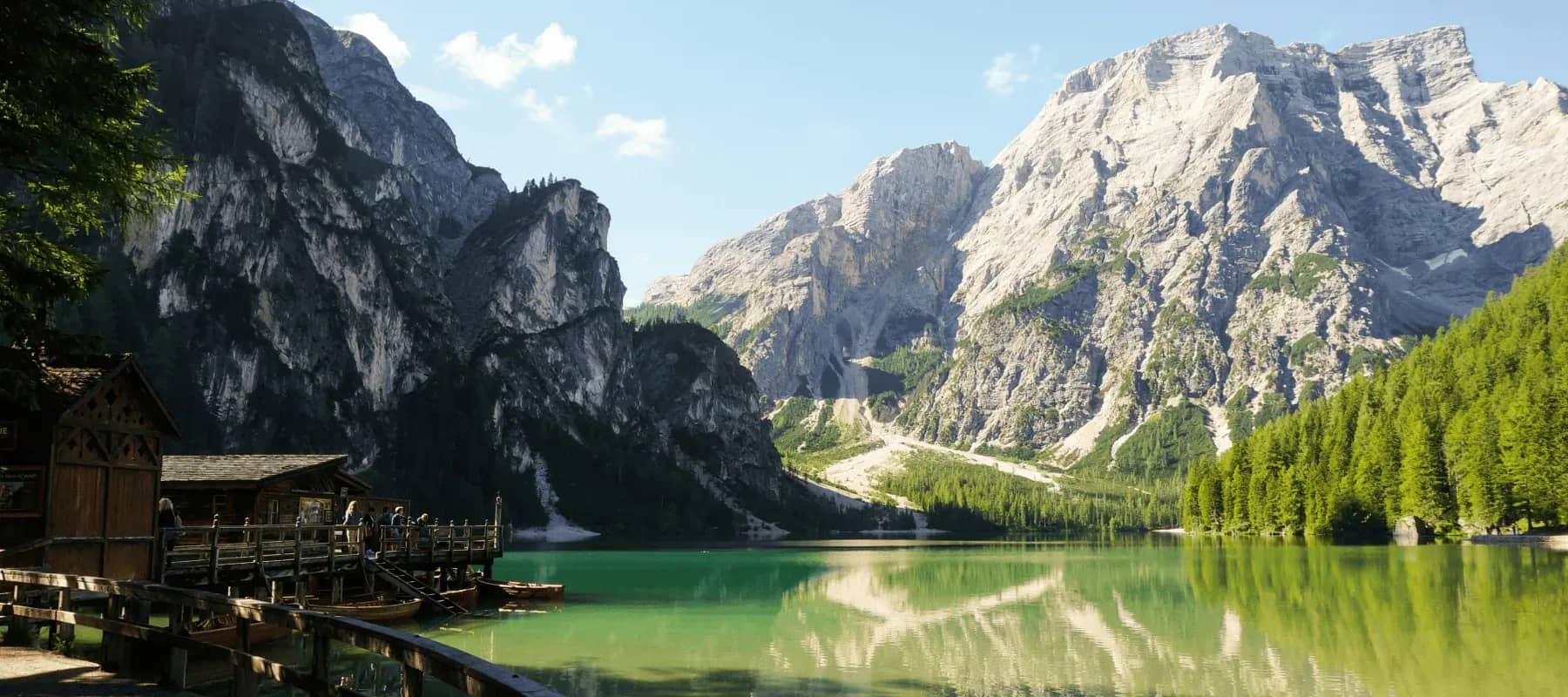 Family meetings, a wooden chalet below steep alpine cliffs and forest.