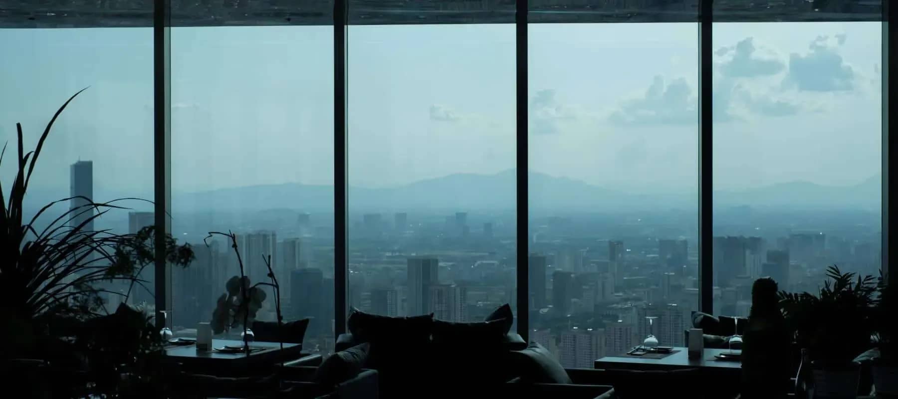 Family office accounting, a city skyline seen through tall windows at dusk.