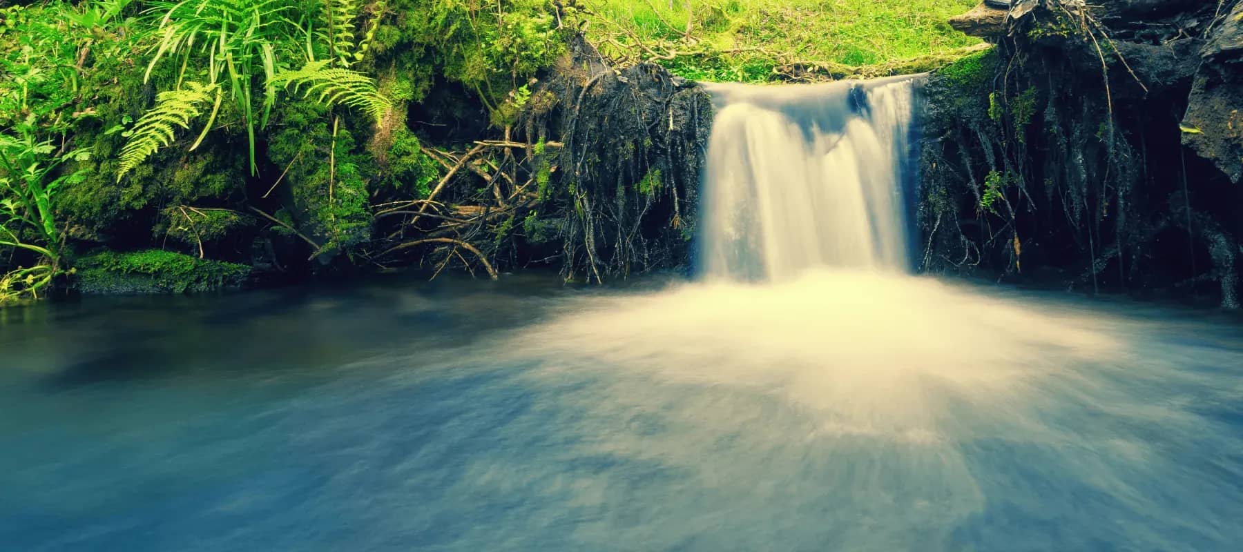 Reshaping global capital markets, a waterfall falling into a turquoise pool.
