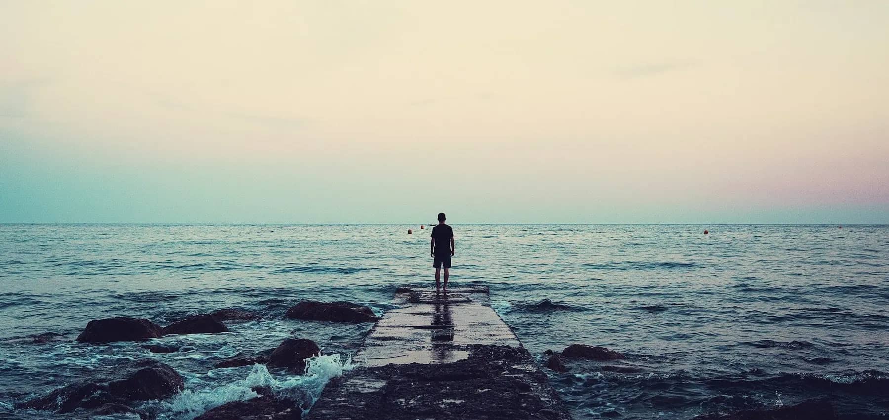 Investment time horizons, a person standing alone in shallow sea looking to the horizon.