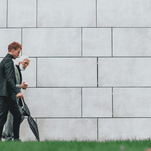 Two businessmen from different generations walking together, symbolising next-gen family office leadership transition