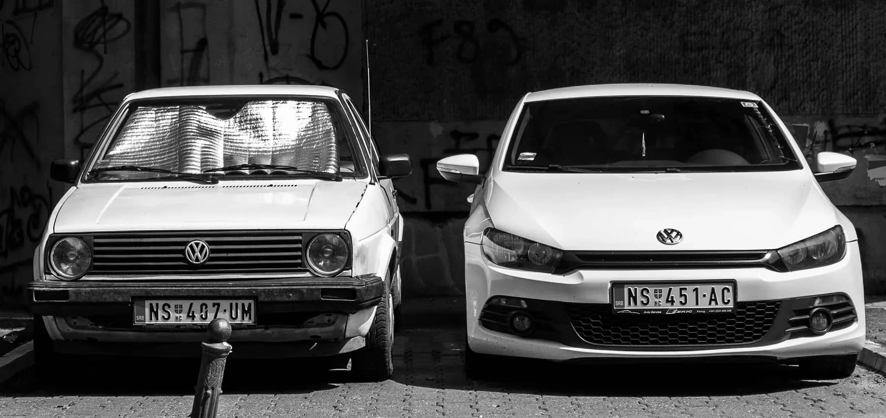 Family business innovation, an older and a newer Volkswagen parked side by side.