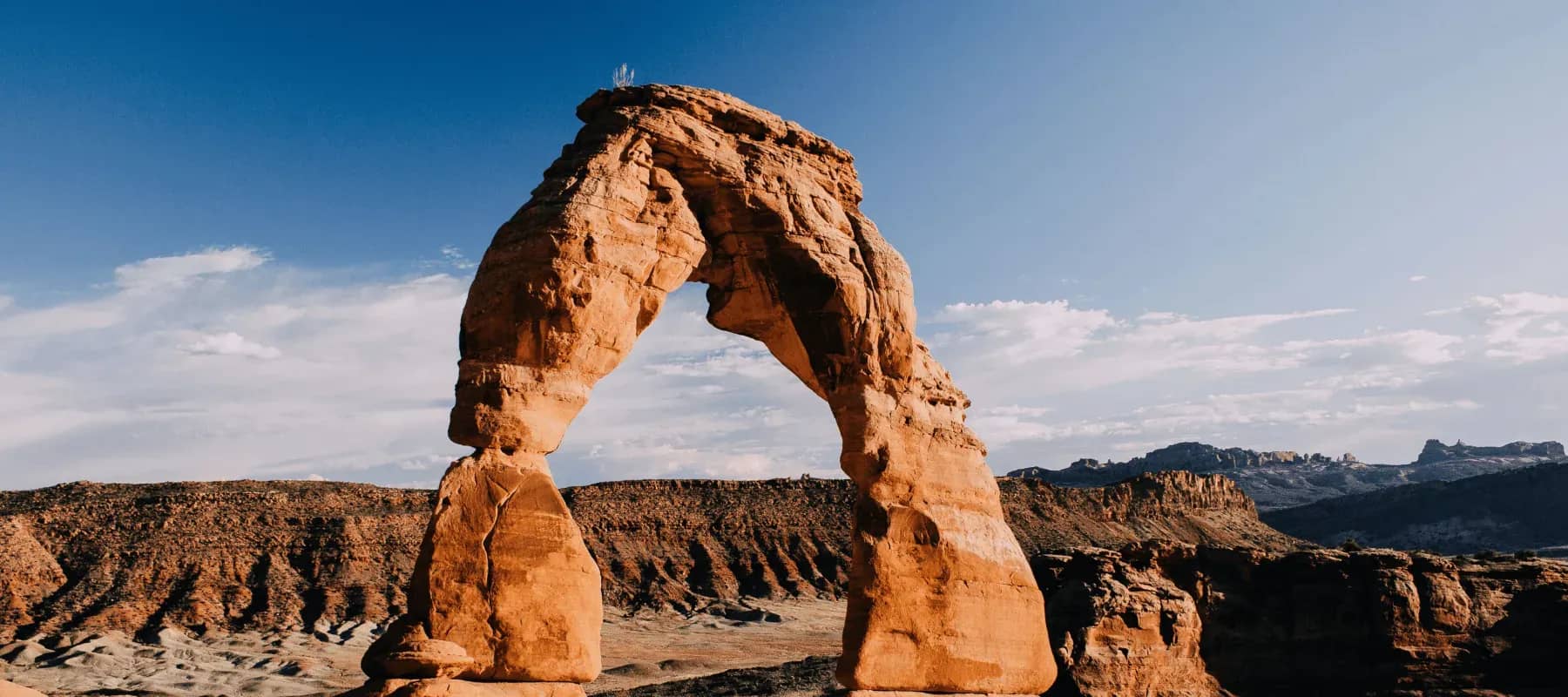 Family offices and risk, a natural sandstone arch standing in desert terrain.