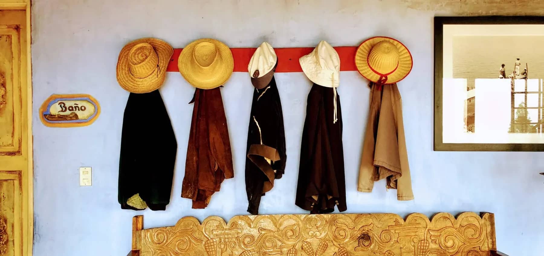 Creating multi-generational wealth, hats and robes hanging in a row on a white wall.
