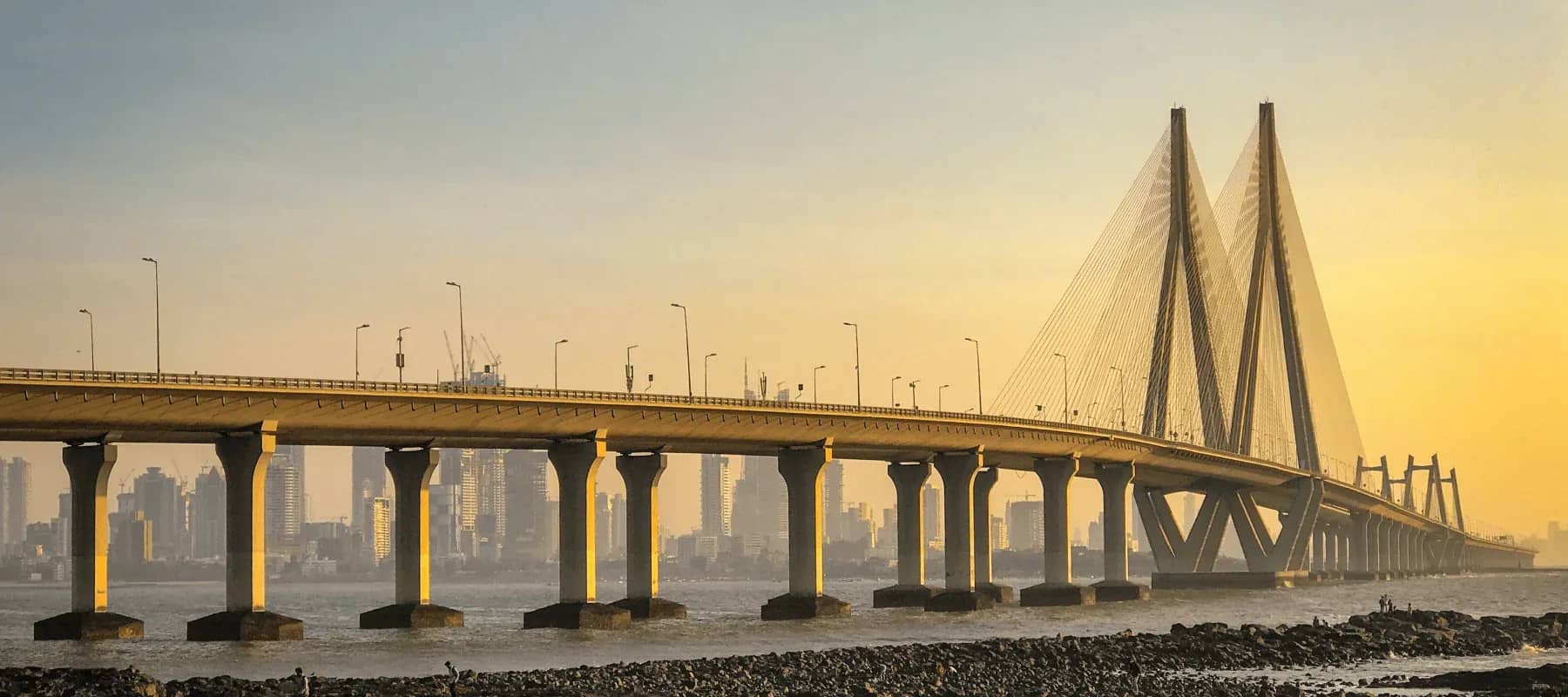Professionalised wealth management in India, a cable-stayed sea bridge at dusk.