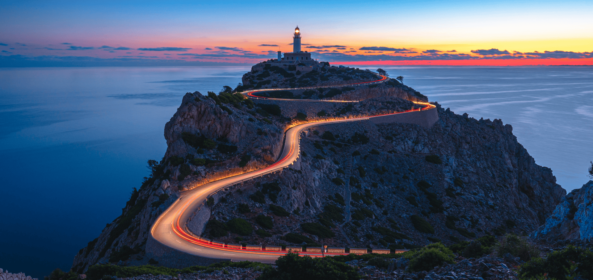 Winding coastal road leading to a lighthouse at sunset, symbolising direction and guidance for family offices