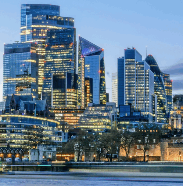 London financial district skyline at dusk with illuminated skyscrapers and River Thames in the foreground