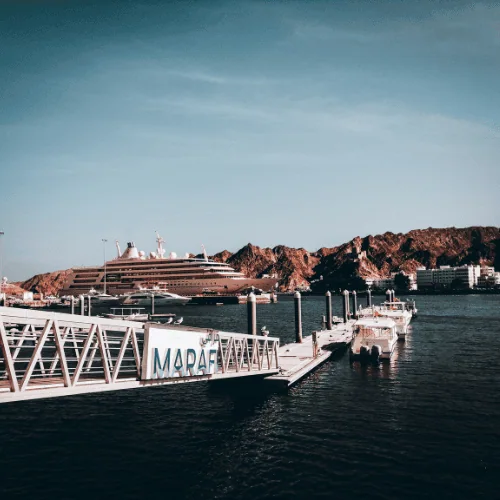Harbour and marina in Oman with yachts and mountains in the background, representing Towell Group’s modernisation and global governance transformation with DiliTrust