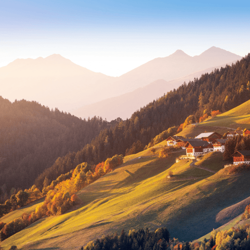 Swiss alpine valley with hillside village and autumn landscape, representing Switzerland as a global hub for family offices